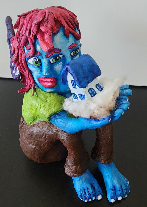 Hatching an Idea sculpture by Christy Strickler showing a seated figure holding a nest with a newly emerged home, created with spun cotton and acrylic paint